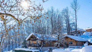 A snow-covered village with wooden houses, a wooden fence, and a clear blue sky. - Simplistic Apartment in Piesendorf - Walchen near Ski Slopes (Piesendorf)