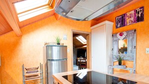 Une cuisine dotée d’un réfrigérateur en acier inoxydable, d’un plan de travail en bois et d’une lucarne.
