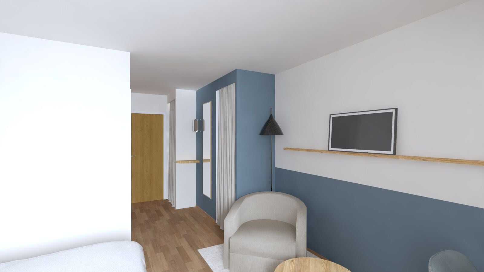 Habitación de hotel con cama, una silla, escritorio, lámpara y televisor en la pared.