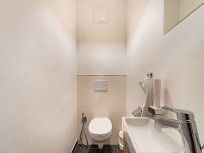 A compact bathroom with a toilet, a sink, and a shower. - Apartment in St. Georgen / Salzburg Near ski Area (Bruck an der Grossglocknerstrasse)