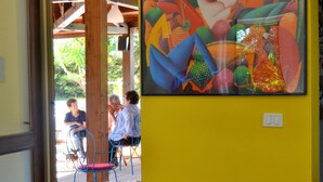A dining area with a table set for two, chairs, and a glass of water. - Belvilla by OYO Holiday Home in Caltagirone (Caltagirone)