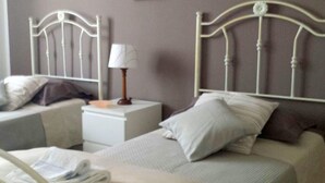A hotel room with two beds, a nightstand with a lamp, and a framed picture on the wall. - Belvilla by OYO Holiday Home in Caltagirone (Caltagirone)
