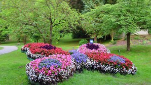 Un jardín con parterres de colores variados y un sendero.