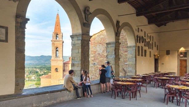 An interior with stone arches, a view of a tower, and tables arranged for dining. - Beautiful Farmhouse With Pool (San Marcello Piteglio)