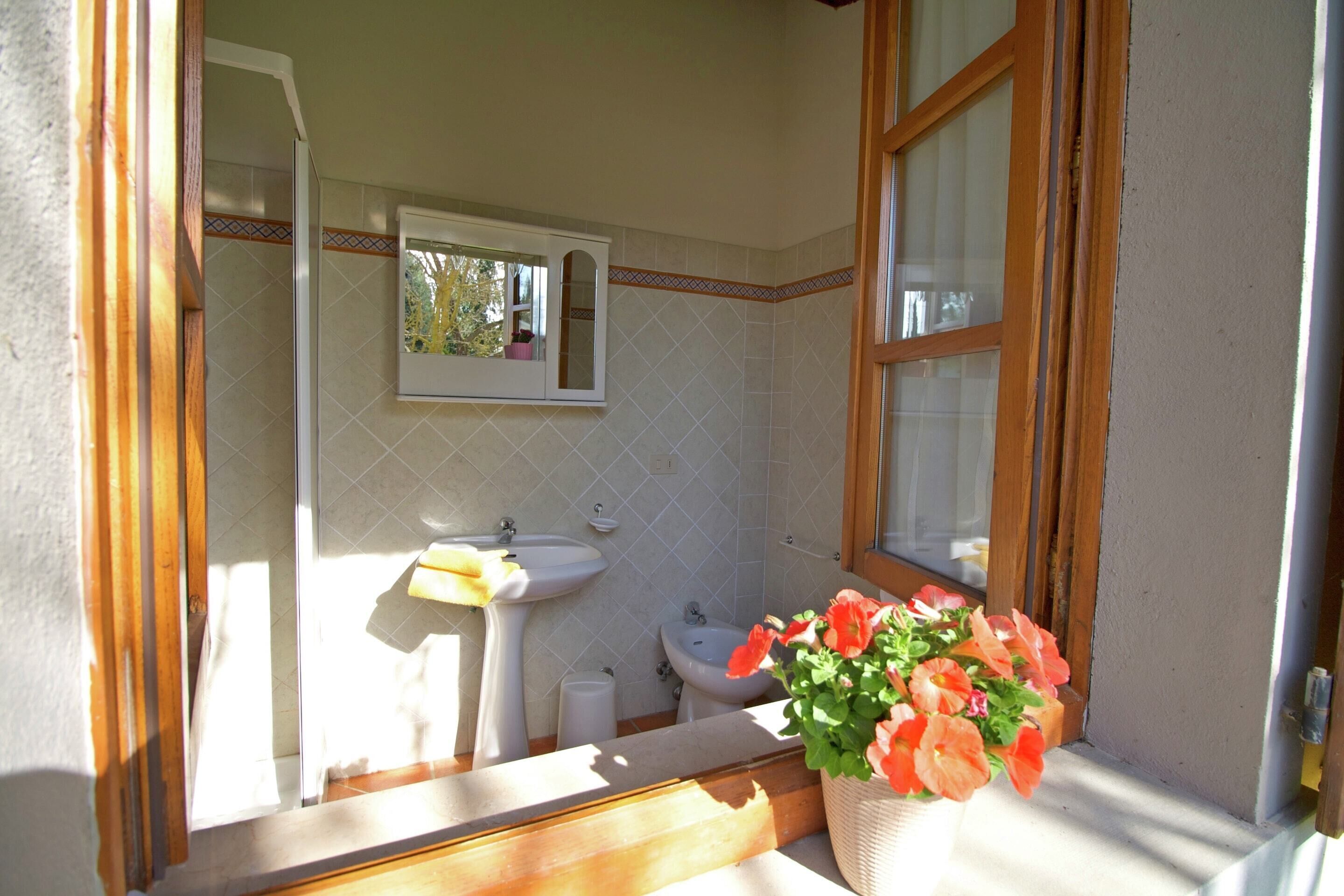 A bathroom with a sink, bidet, and mirror.