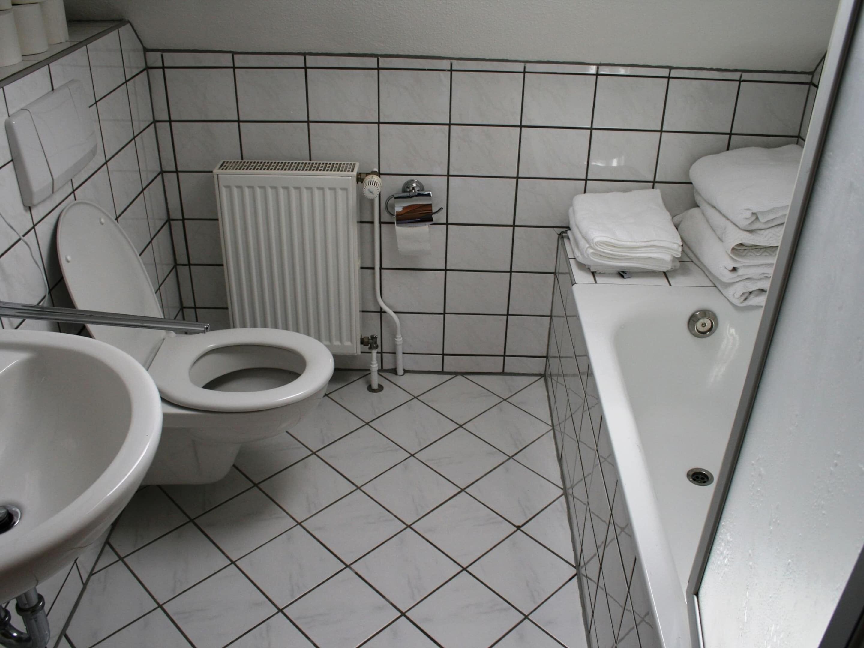 A bathroom with a toilet, sink, and bathtub.