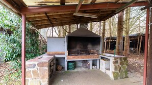 An outdoor barbecue area with a brick oven, stone seating, and a covered shelter. - Pretty Holiday Home near Durbuy & La Roche-en-Ardennes (Erezee)