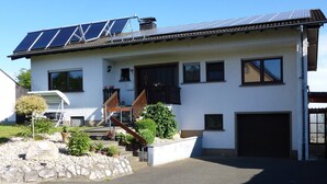 A two-story house with a sloped roof, solar panels, a covered staircase, and a garage. - Apartment in Leudersdorf, Eifel With Terrace (Üxheim)