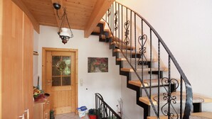 A wooden staircase with black railings, a wooden door with glass panels, and a small rug on the floor. - Apartment in Waldachtal Near the Forest (Waldachtal)
