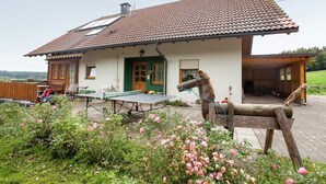 A house with a tiled roof, a green door, and a wooden porch. - Apartment in Waldachtal Near the Forest (Waldachtal)