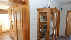 A room with wooden cabinets and a glass-fronted bookcase filled with books. - Apartment in the Middle of Franconian Switzerland (Kunreuth)