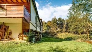 A two-story house with a wooden balcony and a garden area. - Rustic Black Forest Getaway (Masserberg)