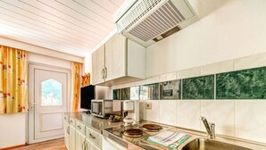 A compact kitchen with a built-in dishwasher, a microwave, and a sink. - Rustic Black Forest Getaway (Masserberg)