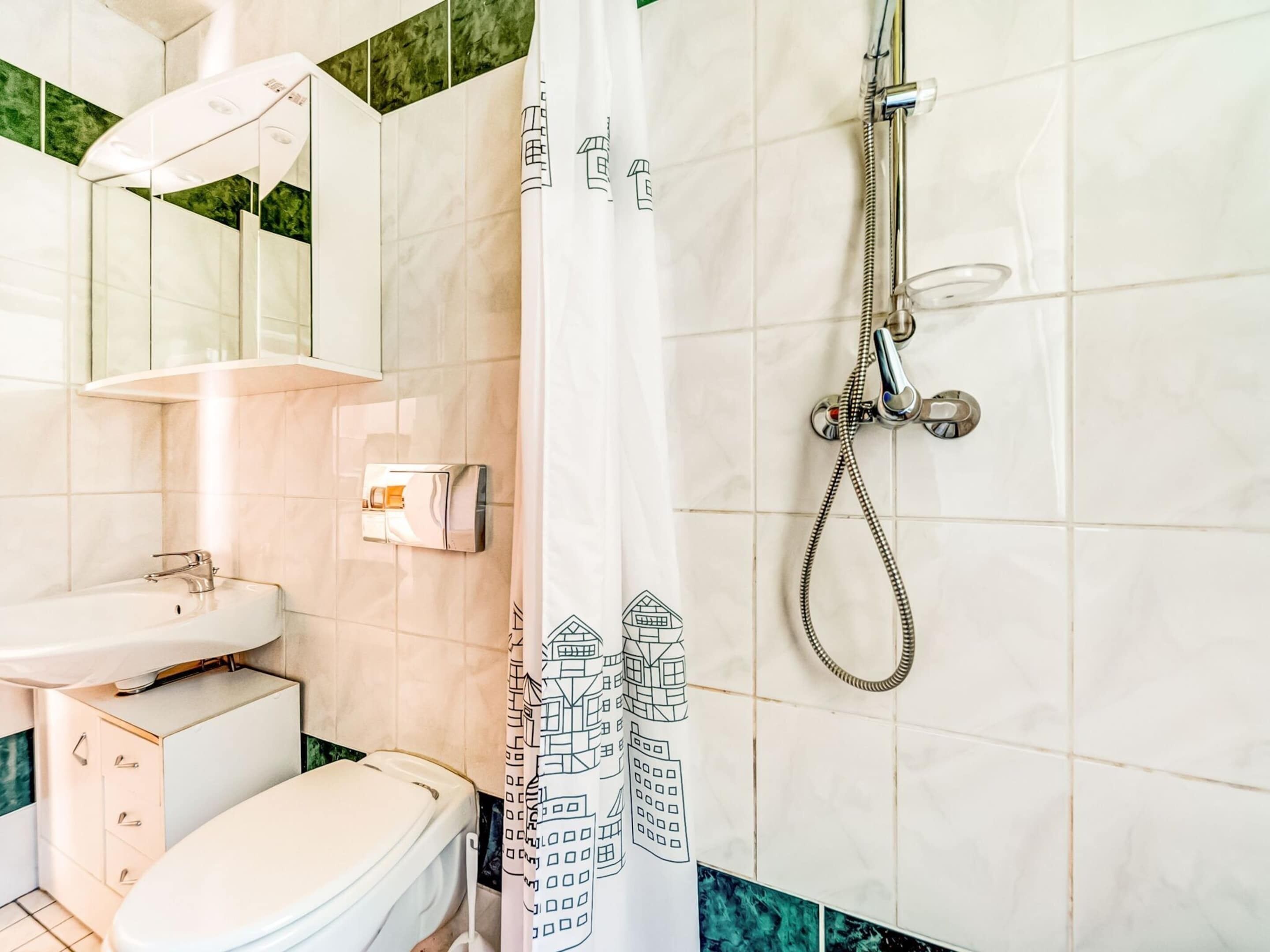 A bathroom with a toilet, sink, and shower.