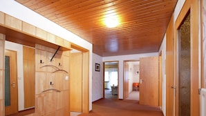 A hallway with wooden lockers, a carpeted floor, and a ceiling light. - Apartment With Garden (Bad Peterstal-Griesbach)