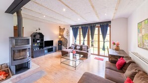 Una sala de estar con chimenea, sofá, mesa de centro y una pared decorativa de piedra.