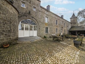 Un bâtiment en pierre doté d’une grande fenêtre en arc de cercle et d’une petite tour.