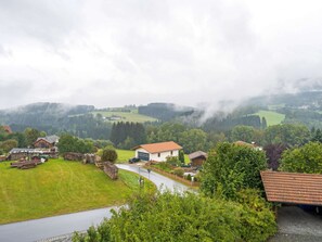 Ett lantligt landskap med hus, en slingrande väg och en skogbeklädd dal.
