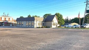 A parking lot with a building that has a flat roof and a sign that reads "C".