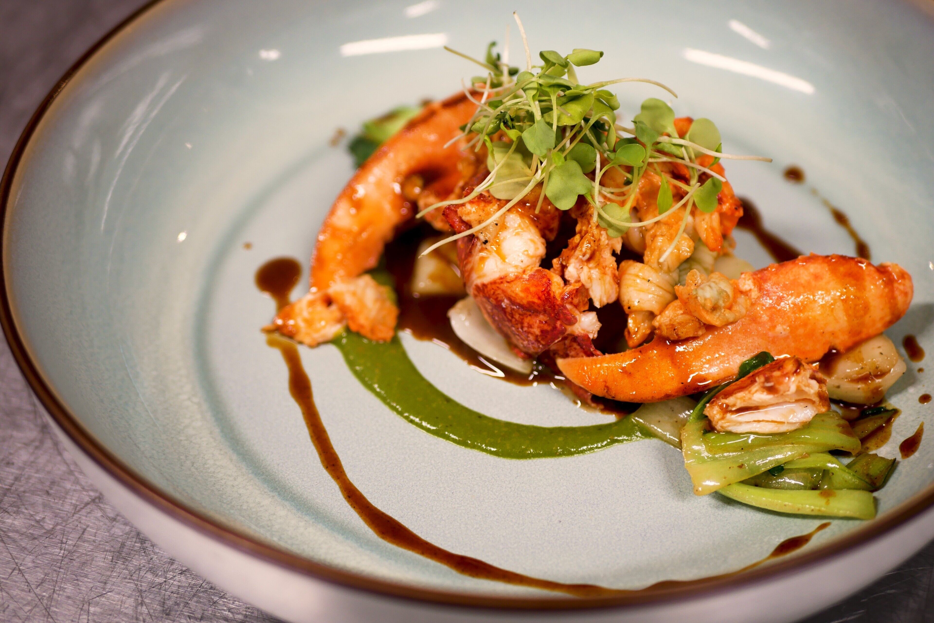 A plate of food with shrimp, greens, and sauce.