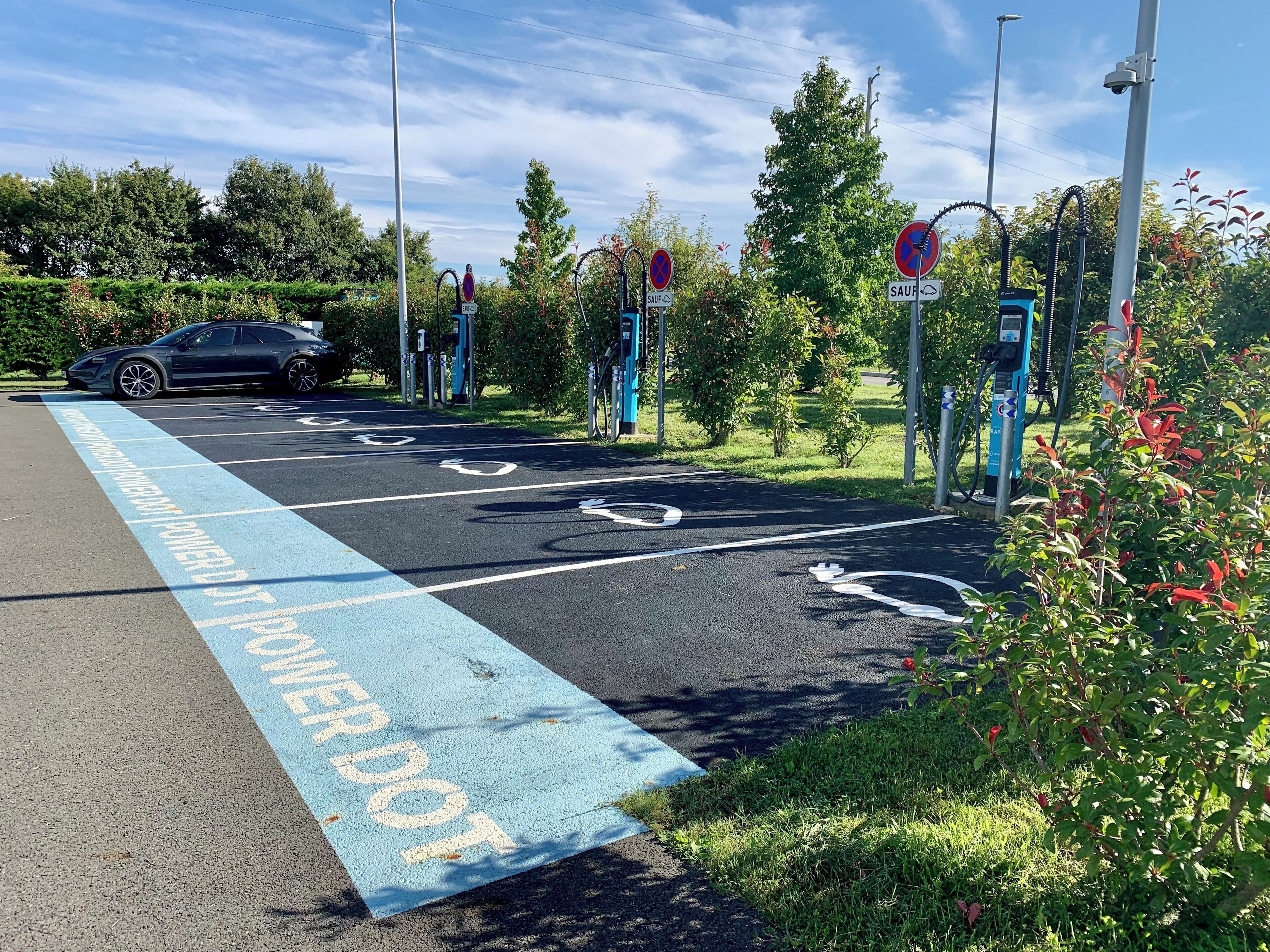 A parking area with electric vehicle charging stations and a designated lane for electric vehicles.