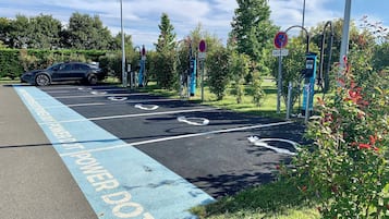 A parking area with electric vehicle charging stations and a designated lane for electric vehicles.
