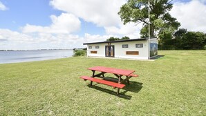 A picnic table in a grassy area with a small building in the background. - Apartment in Hippolytushoef for 2 Guest (Hippolytushoef)