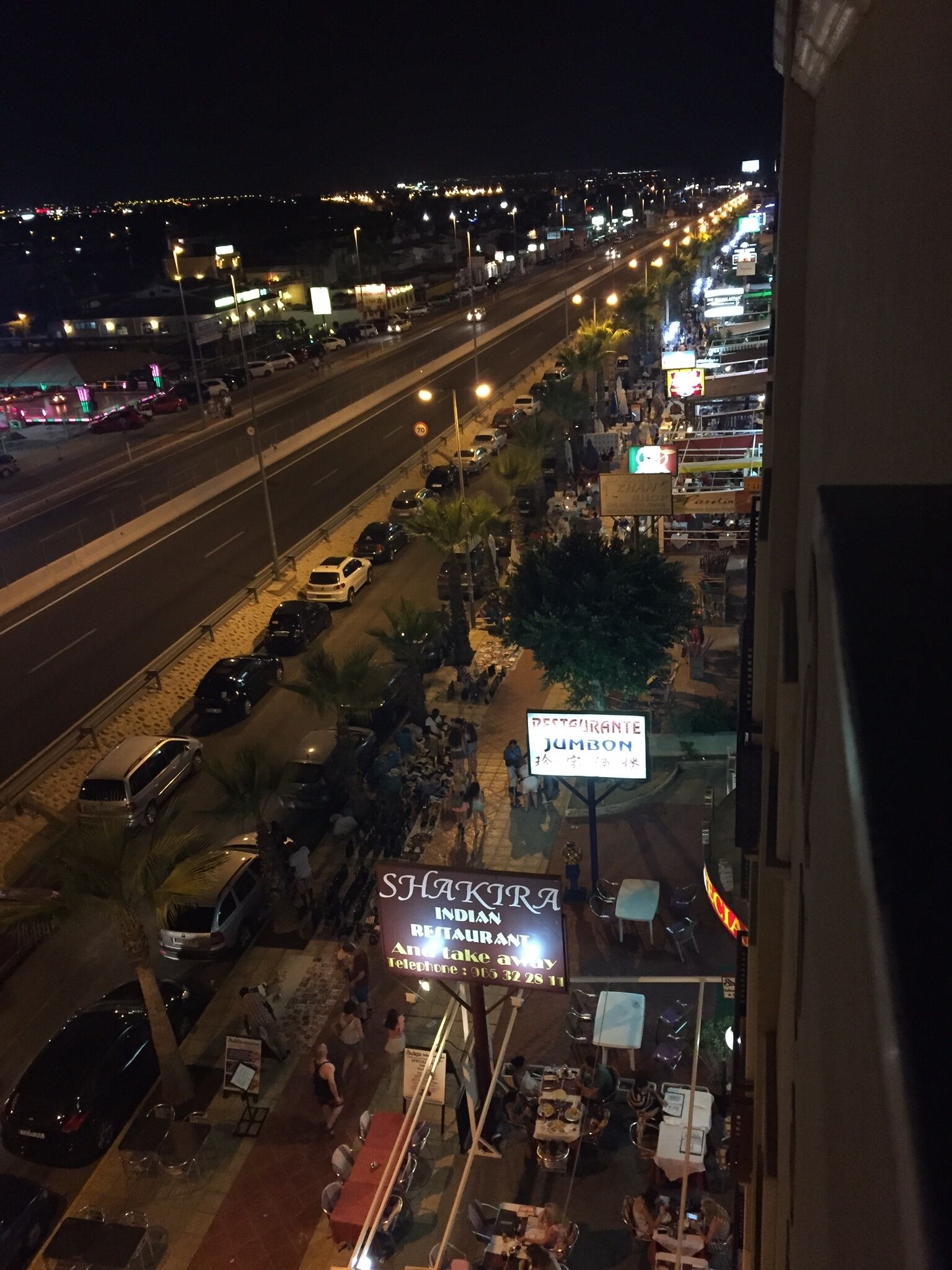 A street view at night with a restaurant named 'Shakira Indian Restaurant' and a sign for 'Restaurant Jumbo' visible.