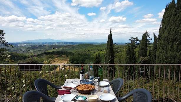 A table set for a meal with a scenic view of a valley and mountains. - Agriturismo Le Case di San Vivaldo (Montaione)