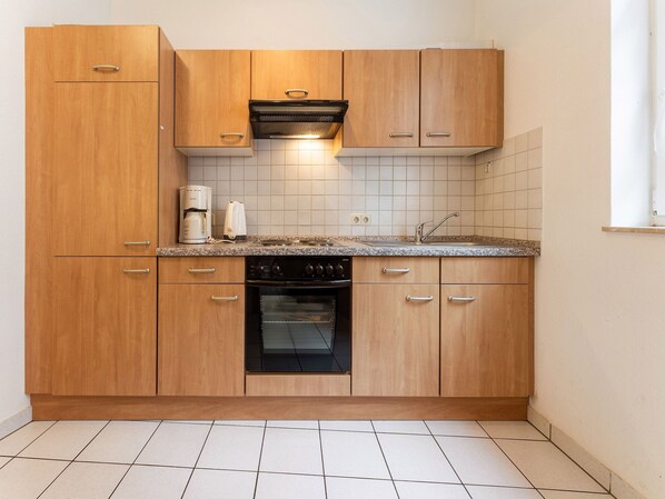Enjoy cooking and brewing in this well-equipped kitchen with oven, stovetop, coffee maker, and kettle.