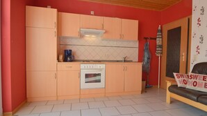 A compact kitchen with a built-in oven, a coffee maker, and a sink.