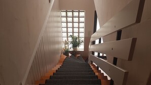 A staircase with a view of a window and a plant.