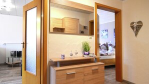 A room with a wooden cabinet, a mirror, and a heart-shaped decoration on the wall.