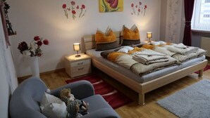 A bedroom with a bed, bedside tables, and a nightstand. - Cozy Apartment in Strotzbüsch near Eifel Center (Strotzbusch)