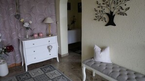 A room with a white dresser, a bench, a wall-mounted tree decoration, and a patterned rug. - Cozy Apartment in Strotzbüsch near Eifel Center (Strotzbusch)