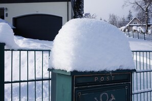 A snow-covered mailbox with the word 'POST' on it, a metal fence, and a garage door in the background. - Fantastic Apartment in Frauenwald near Forest (Ilmenau)