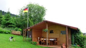 A wooden cabin with a dining area and a flagpole. - Graceful Apartment with Garden in Velmede near City Center (Bestwig)