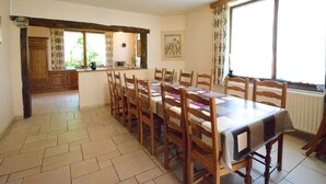 A dining area with a long table and chairs, a kitchen area with a microwave, and a window with curtains. - Spacious Retreat, Daverdisse (Daverdisse)