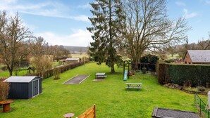 A grassy backyard with a swing set, a picnic table, and a shed. - Cottage With Garden, Lessive (Rochefort)