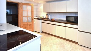 Una cocina moderna con armarios blancos, un microondas integrado y una estufa.