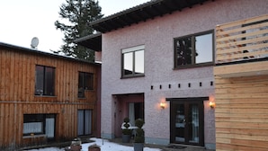 A two-story building with a pink exterior and wooden accents. - Apartment Manderscheid Near Castle Ruins (Manderscheid)