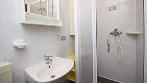A bathroom with a sink, mirror, and shower. - Holiday Apartment Medulin 1 - Elena (Medulin)