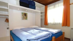 Un dormitorio con dos camas, un armario y un cuadro en la pared.
