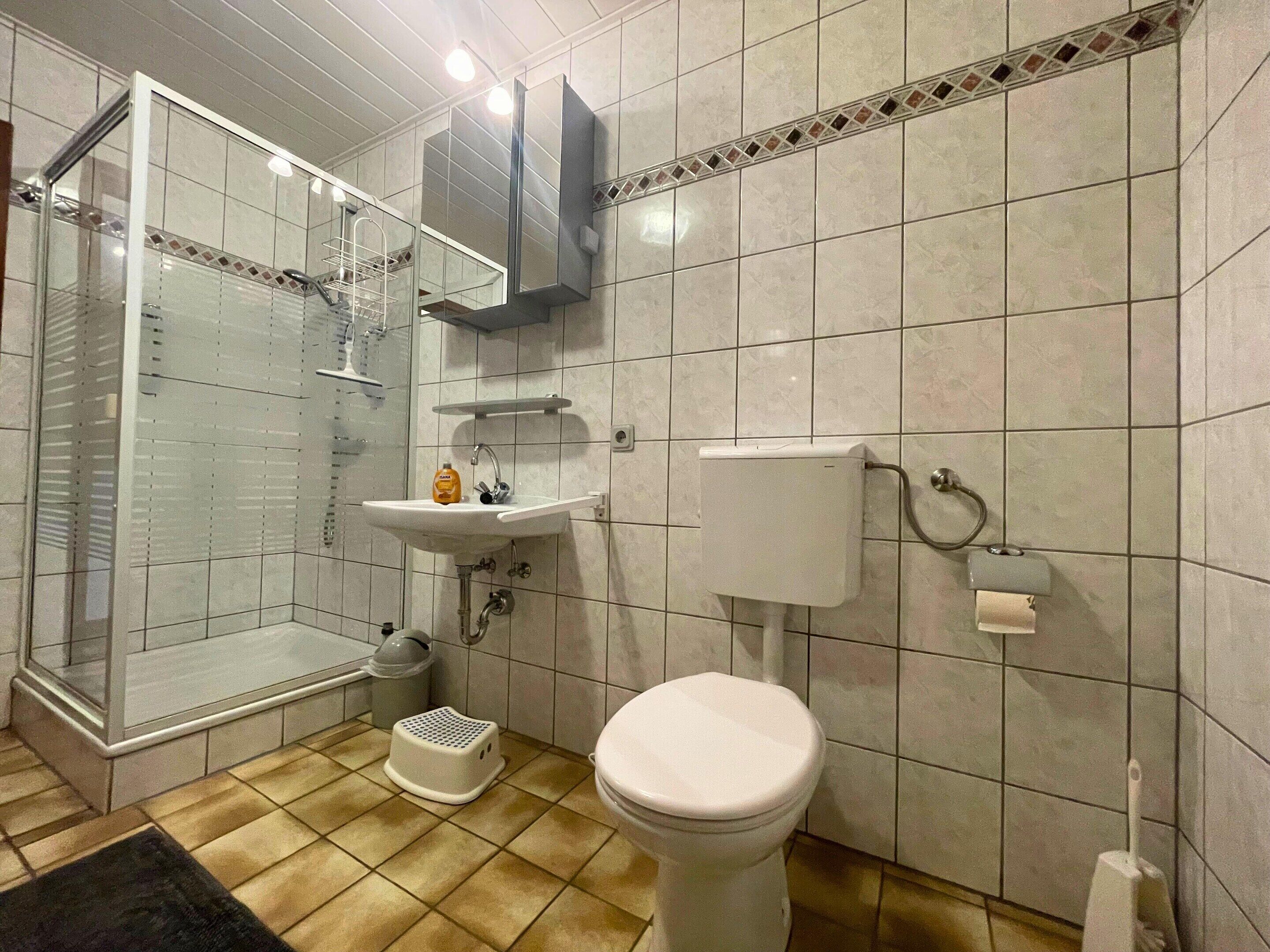 A bathroom with a toilet, sink, and shower.