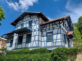 Uma casa tradicional de enxaimel com varanda e telhado inclinado.