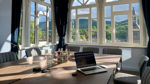 Ein Konferenzraum mit einem Holztisch, einem Laptop und einem Flaschenhalter.