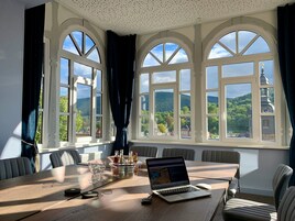 Uma sala de conferências com uma mesa de madeira, um laptop e um porta-garrafa.