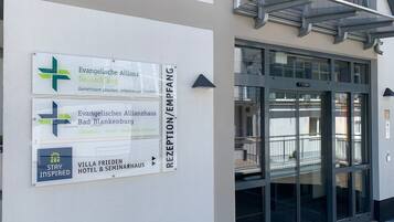 Zona de recepción con señales direccionales para la Evangelische Allianz Deutschland, el Evangelisches Allianzhaus Bad Blankenburg y el Hotel & Seminarios Villa Frieden.