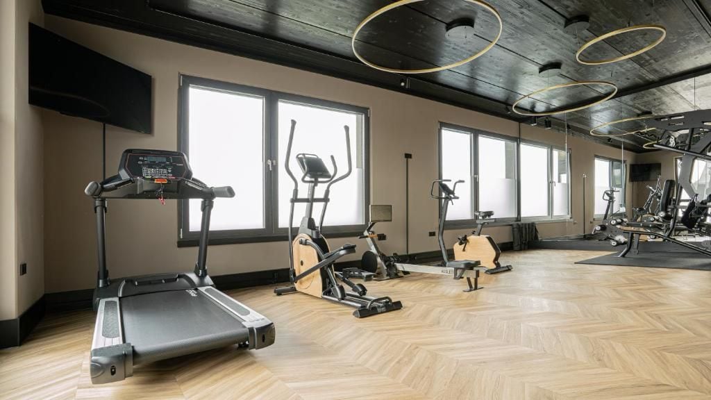 Een sportschool met loopbanden, elliptische trainers en hometrainers.