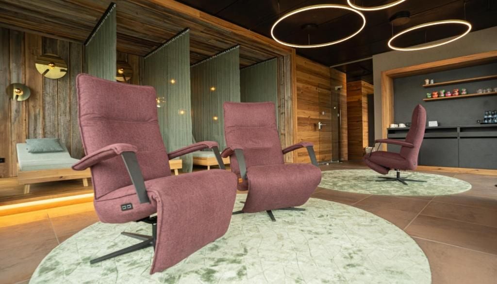 Un interno moderno con due poltrone viola, una parete in legno e un angolo bar.